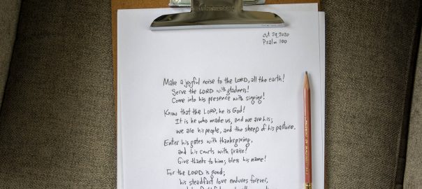 Psalm 100 hand-written with pencil on paper, with clipboard